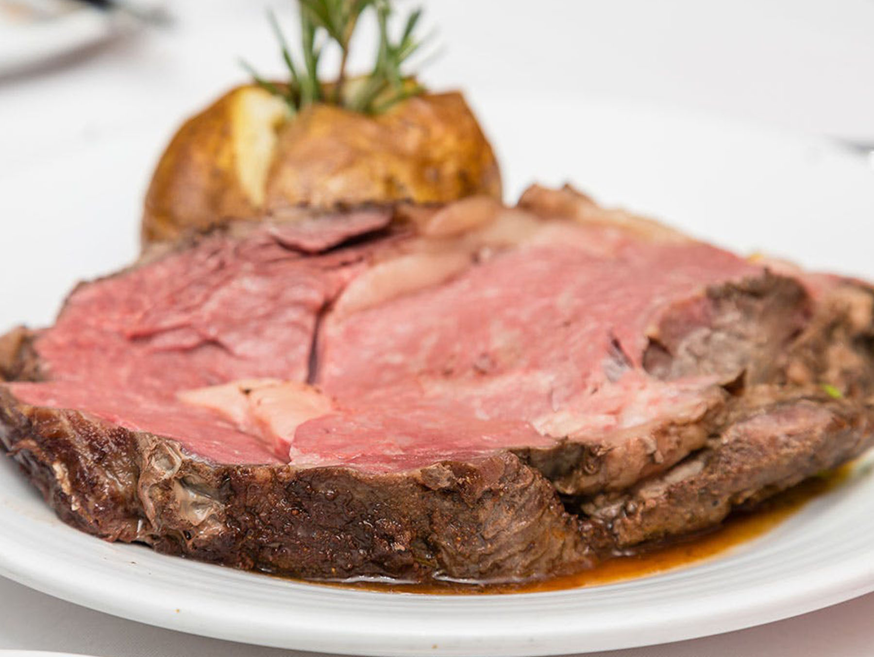 Prime Rib on a white plate with potato