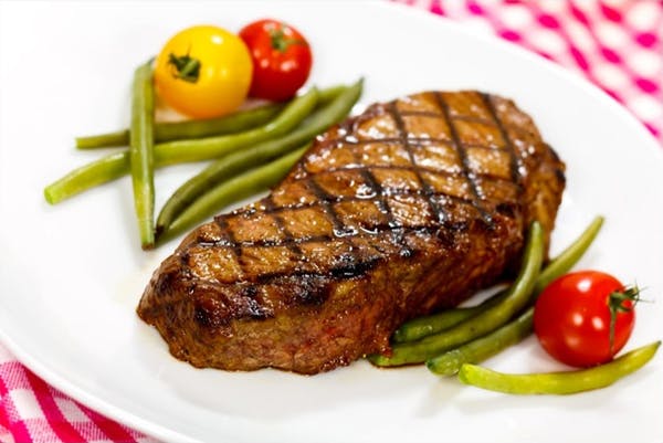 Steak and veggies on a white plate